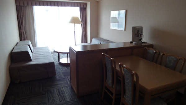 hotel suite living room with a western table and four chairs and two couches with a coffee table between them
